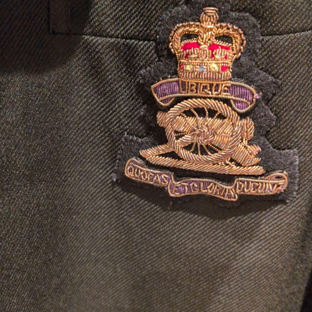 黒いテーラードジャケット 王冠エンブレム付き